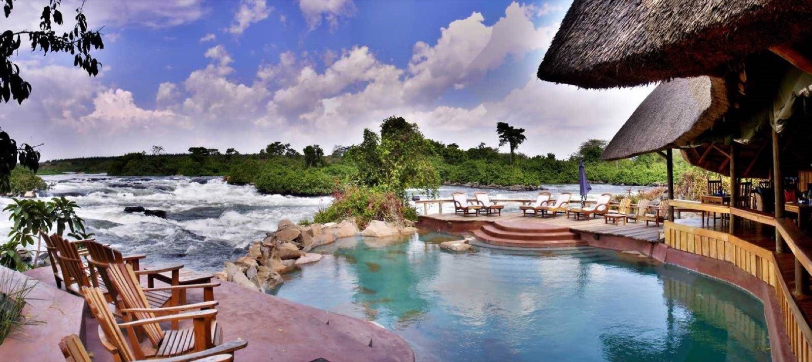 A lodge terrace and pool looking out over white water on the Nile